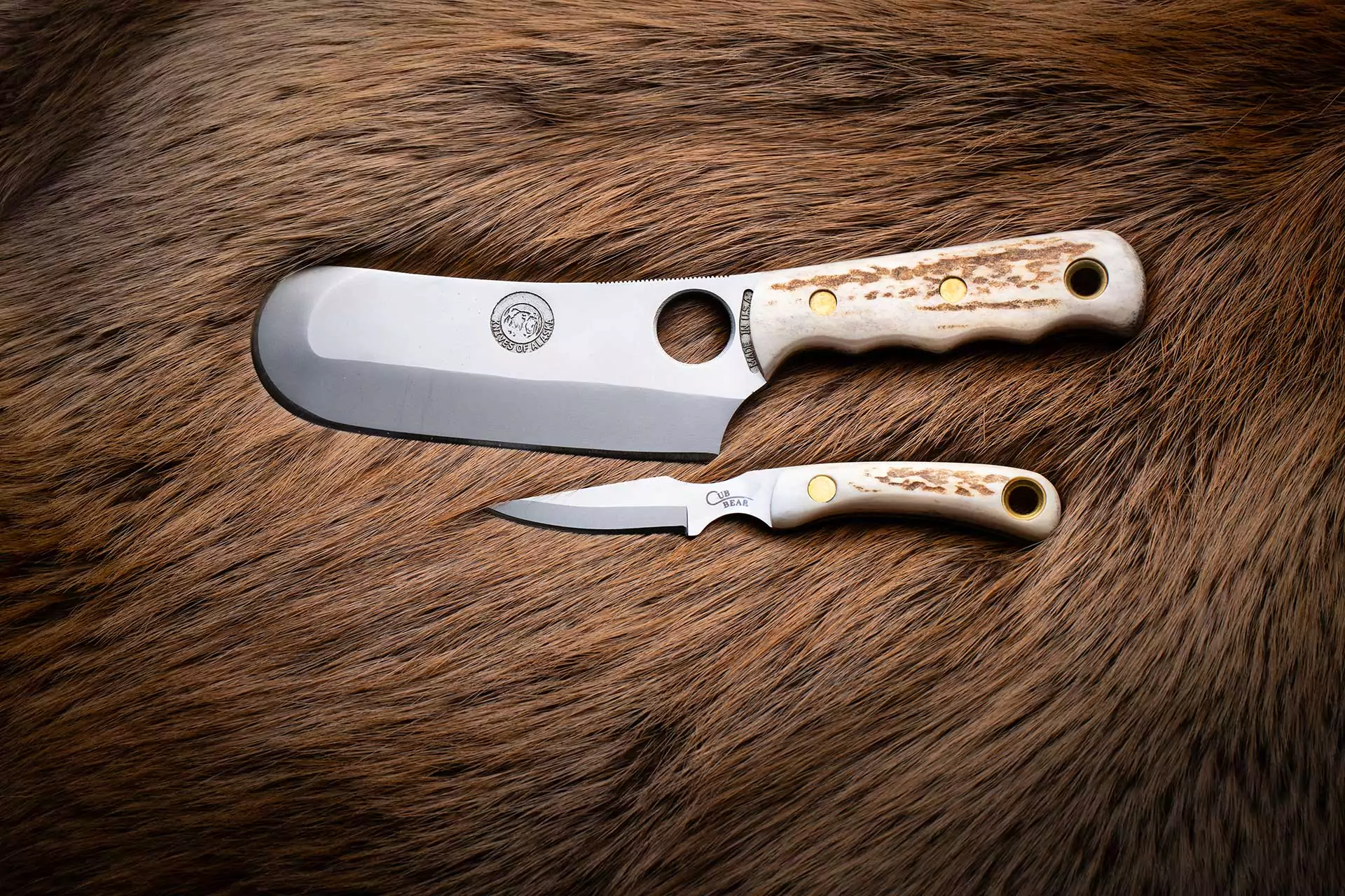 Brown Bear and Cub Bear knife combo with stag handles on suede background