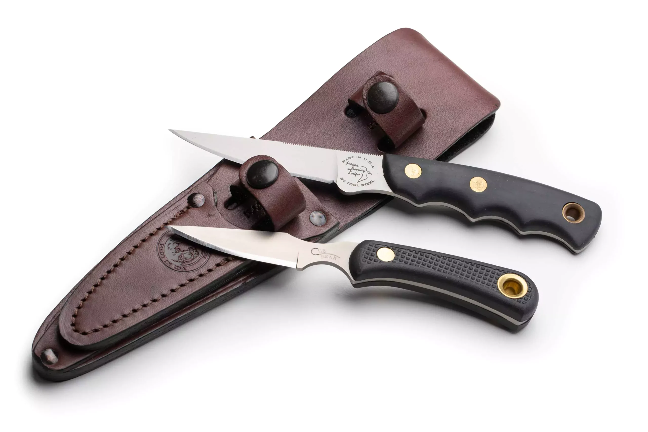 Knives of Alaska Jaeger and Cub Bear knives with black Suregrip handles displayed next to a brown leather sheath.