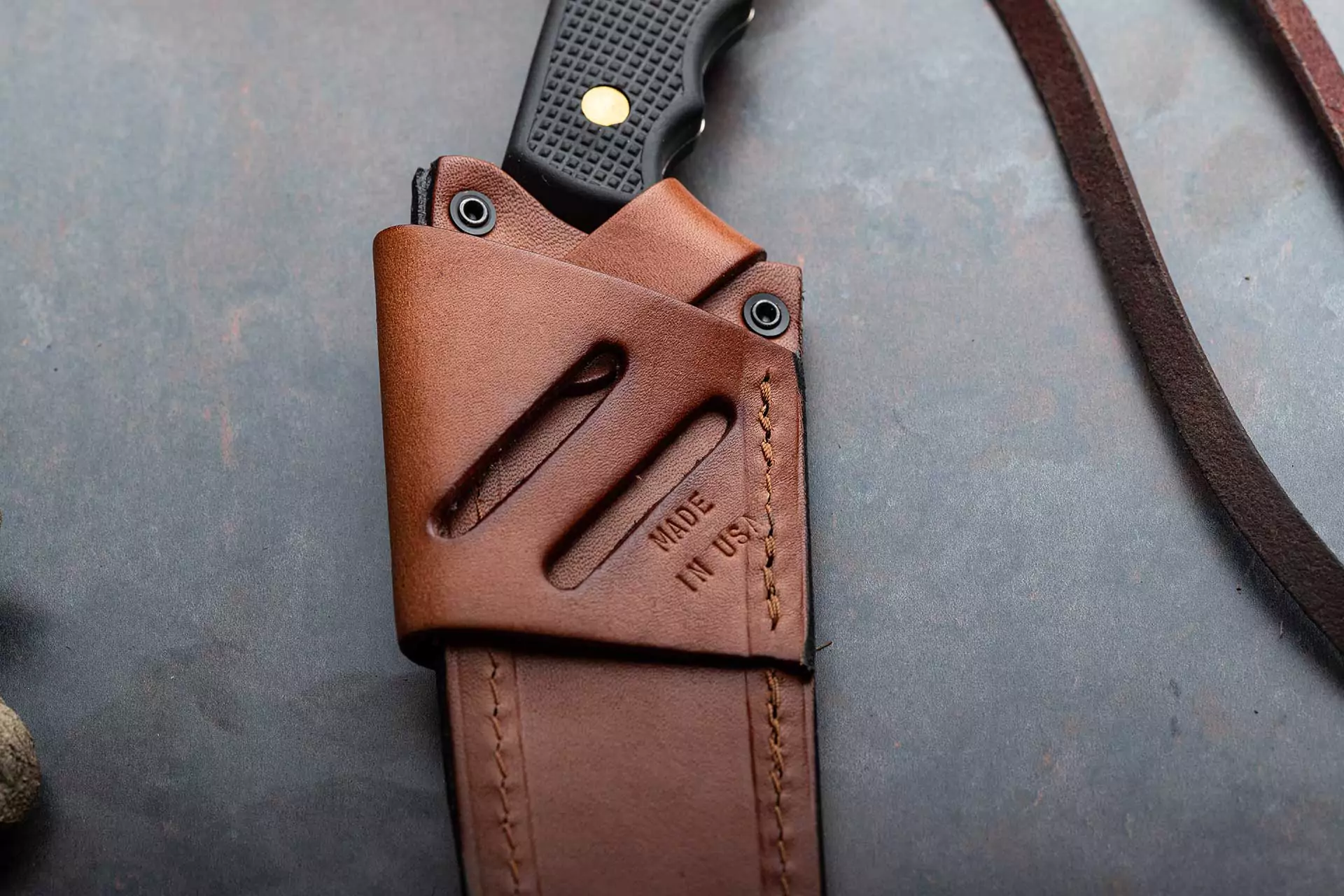 Knives of Alaska wood saw with black Suregrip handle in leather sheath