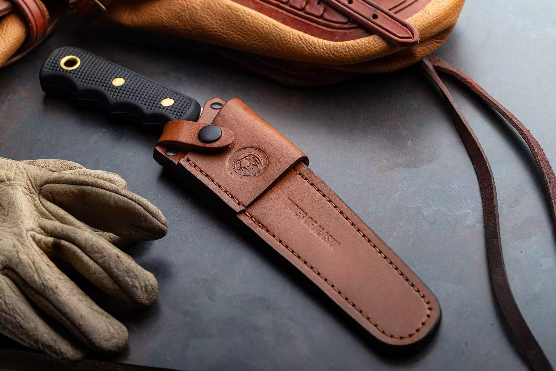 Knives of Alaska wood saw with black Suregrip handle in leather sheath
