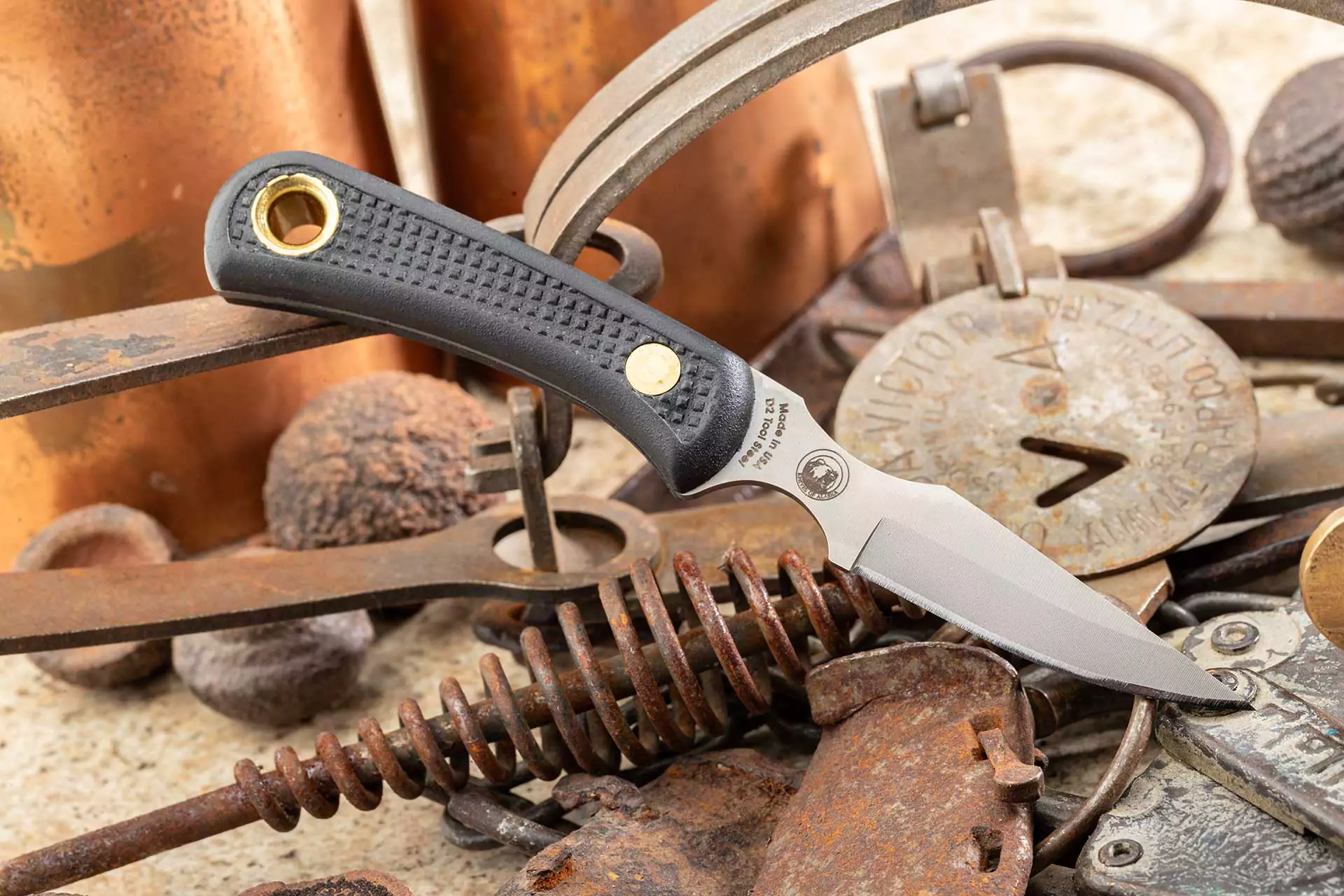 Cub Bear knife with black Suregrip handle displayed on rusty vintage tools