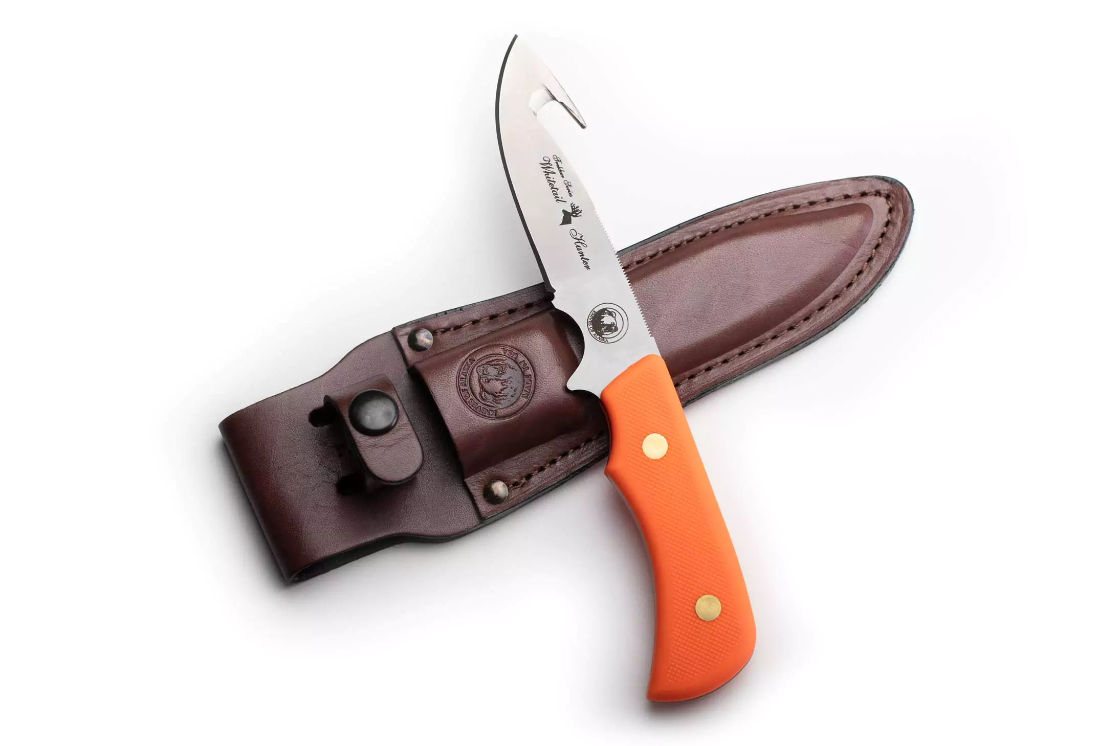 Trekker Whitetail knife with orange Suregrip handle and brown leather sheath.